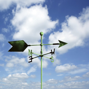 green copper wind vane with bright sky, square frame